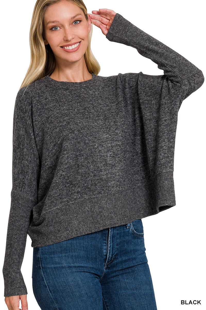 Woman wearing a gray sweater and blue jeans on a white background