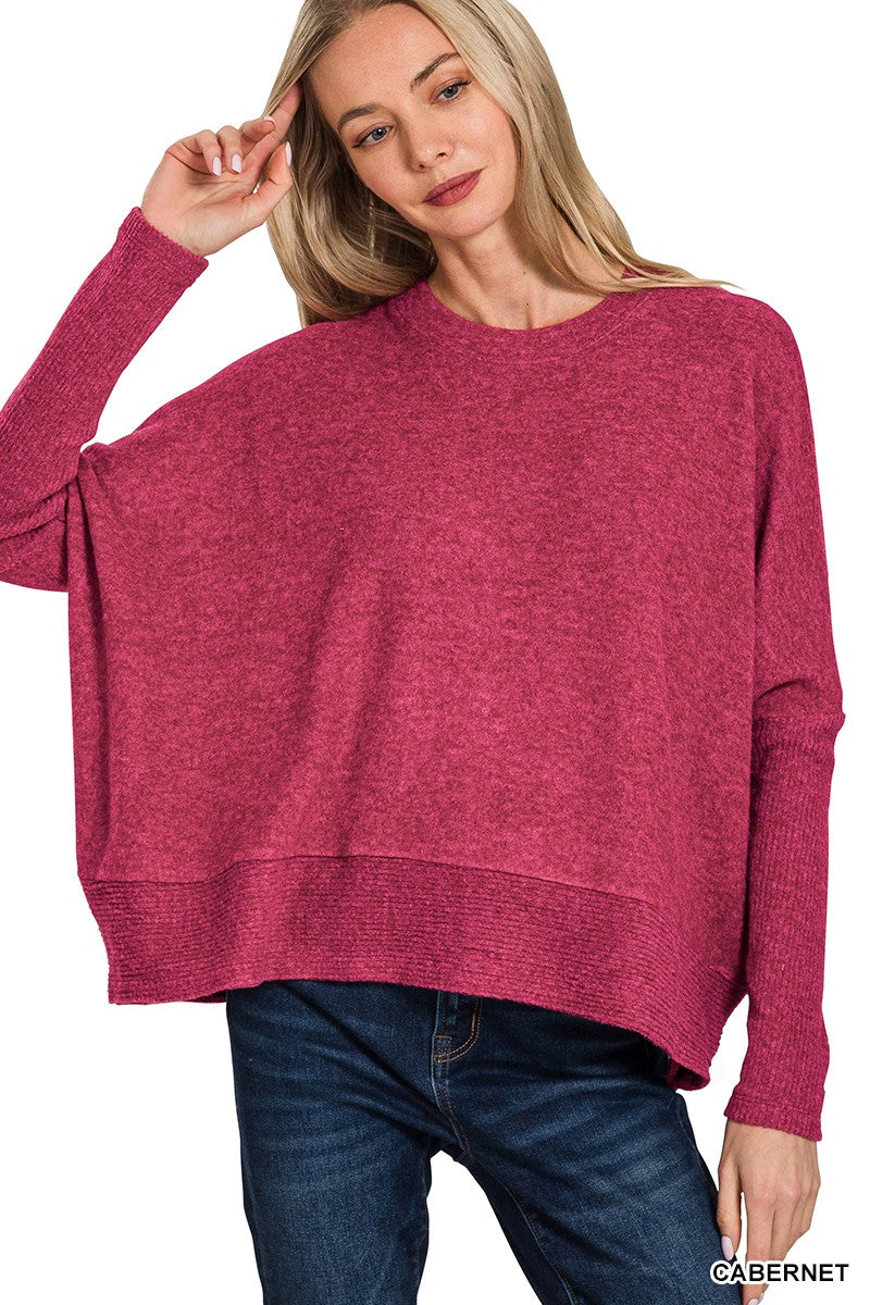 Woman wearing a pink sweater and blue jeans on a white background