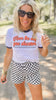 Woman wearing a graphic t-shirt and checkered shorts outdoors