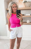 Close-up of white shorts styled with fuschia tank top and sandals for an everyday look