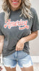 Charcoal gray garment-dyed t-shirt featuring distressed “America” lettering.