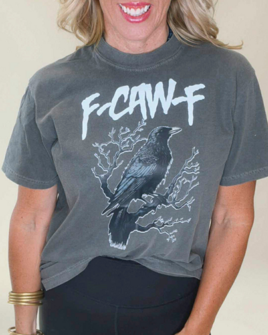 Person wearing a gray t-shirt with a graphic design of a crow and text.