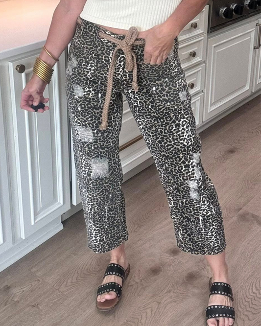 Person wearing leopard print pants with a drawstring in a kitchen.