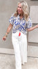 Bold printed puff sleeve blouse featuring smocked neckline and tassels.
