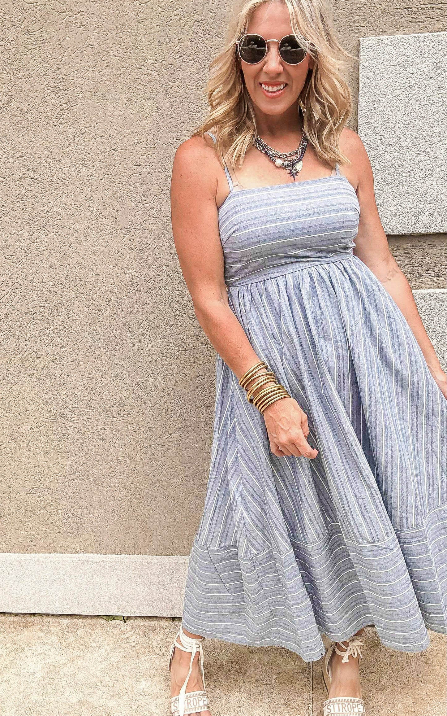 Lightweight maxi dress in vertical blue stripes, featuring spaghetti straps and gathered waist.