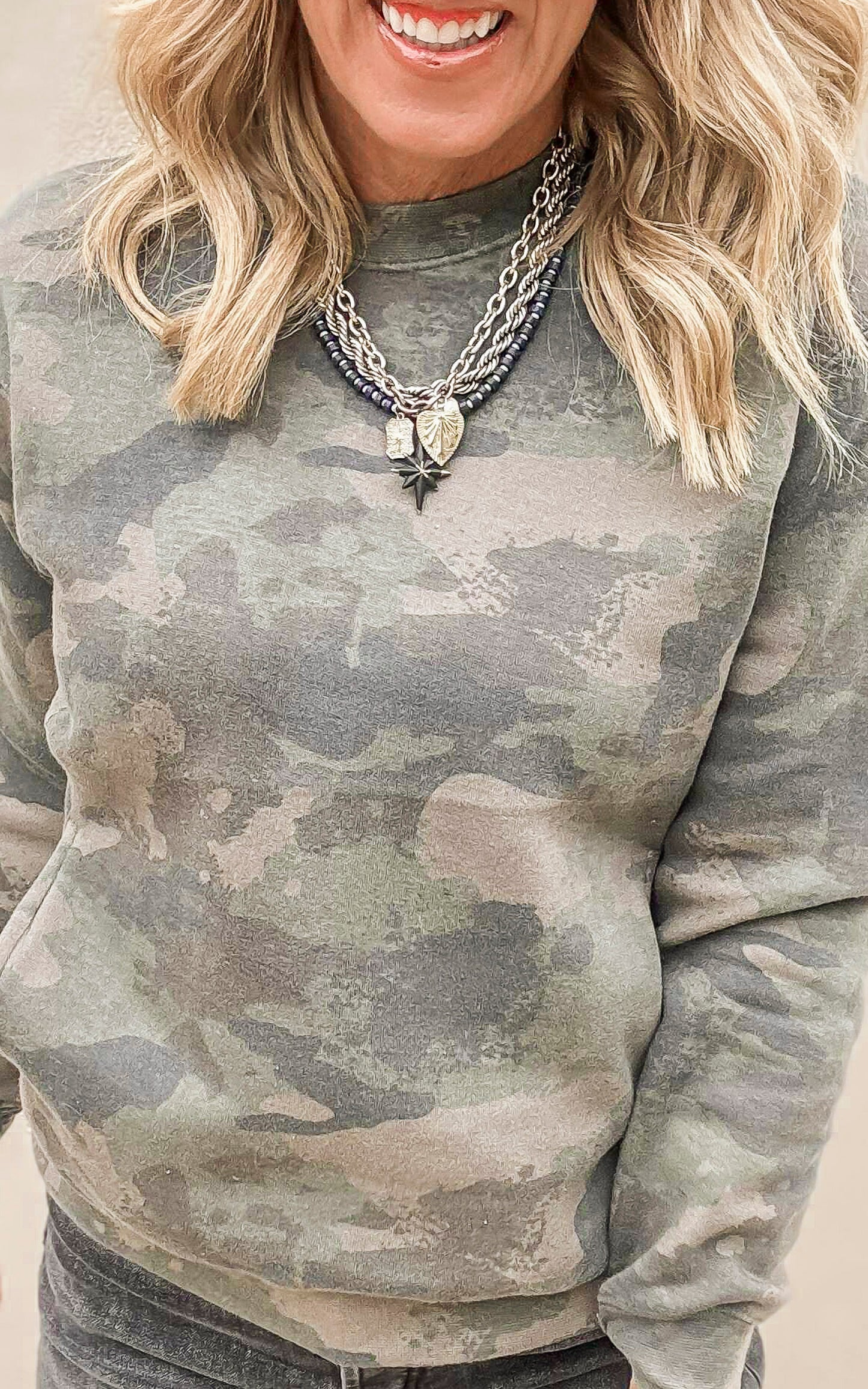 Cloud fleece sweatshirt in muted camo pattern, styled effortlessly for a comfy summer look.
