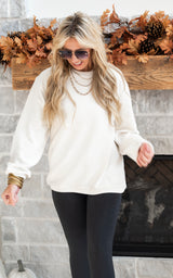 Ivory ribbed sweatshirt paired with black legggings