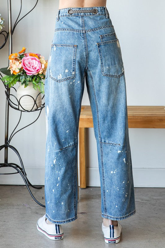 Light wash denim joggers with raw edge distressing styled