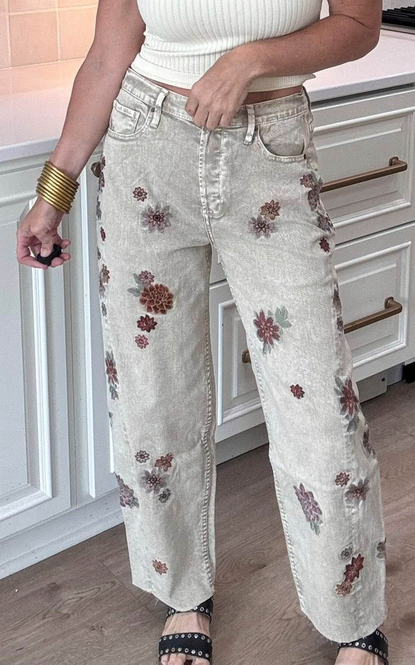 Grey denim jeans with white side stripes and subtle floral embroidery accents.
