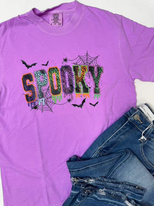 Purple t-shirt with 'Spooky' design and jeans on a white background
