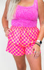 Person wearing a pink checkered outfit with a white background