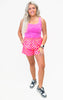 Woman wearing a pink tank top and checkered shorts on a white background