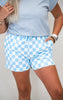 Person wearing light blue and white checkered shorts with a plain background