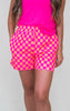 Person wearing pink and orange checkered shorts with a pink top on a white background