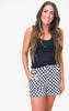 Woman wearing a black tank top and checkered shorts on a white background