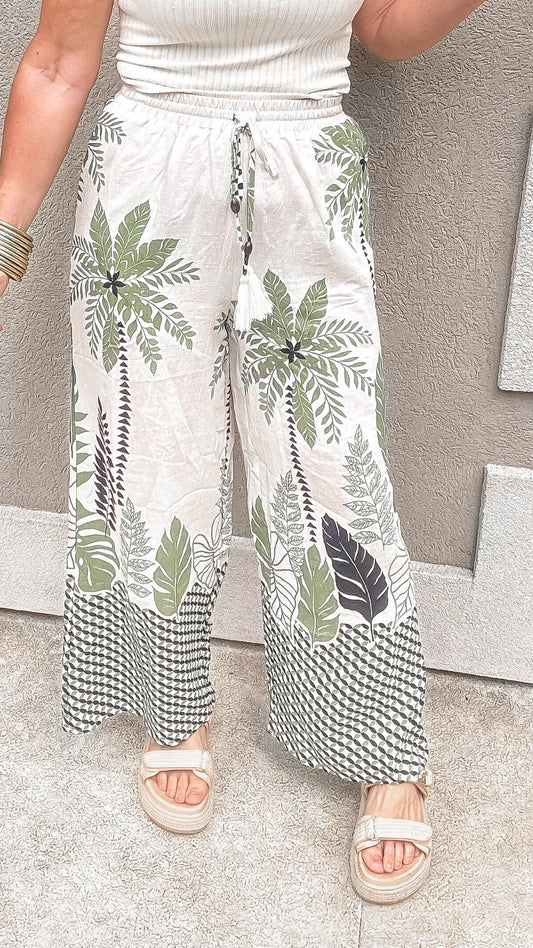 Tropical palm tree print wide-leg pants with drawstring waist.