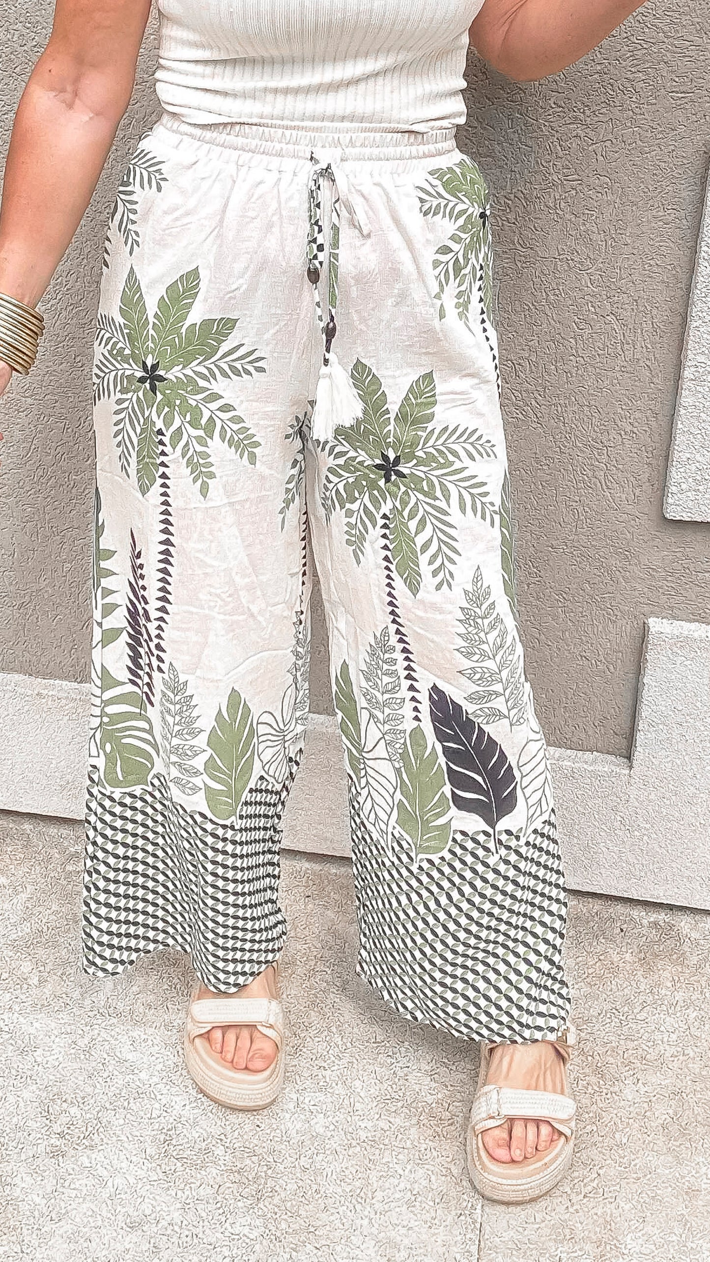 Tropical palm tree print wide-leg pants with drawstring waist.