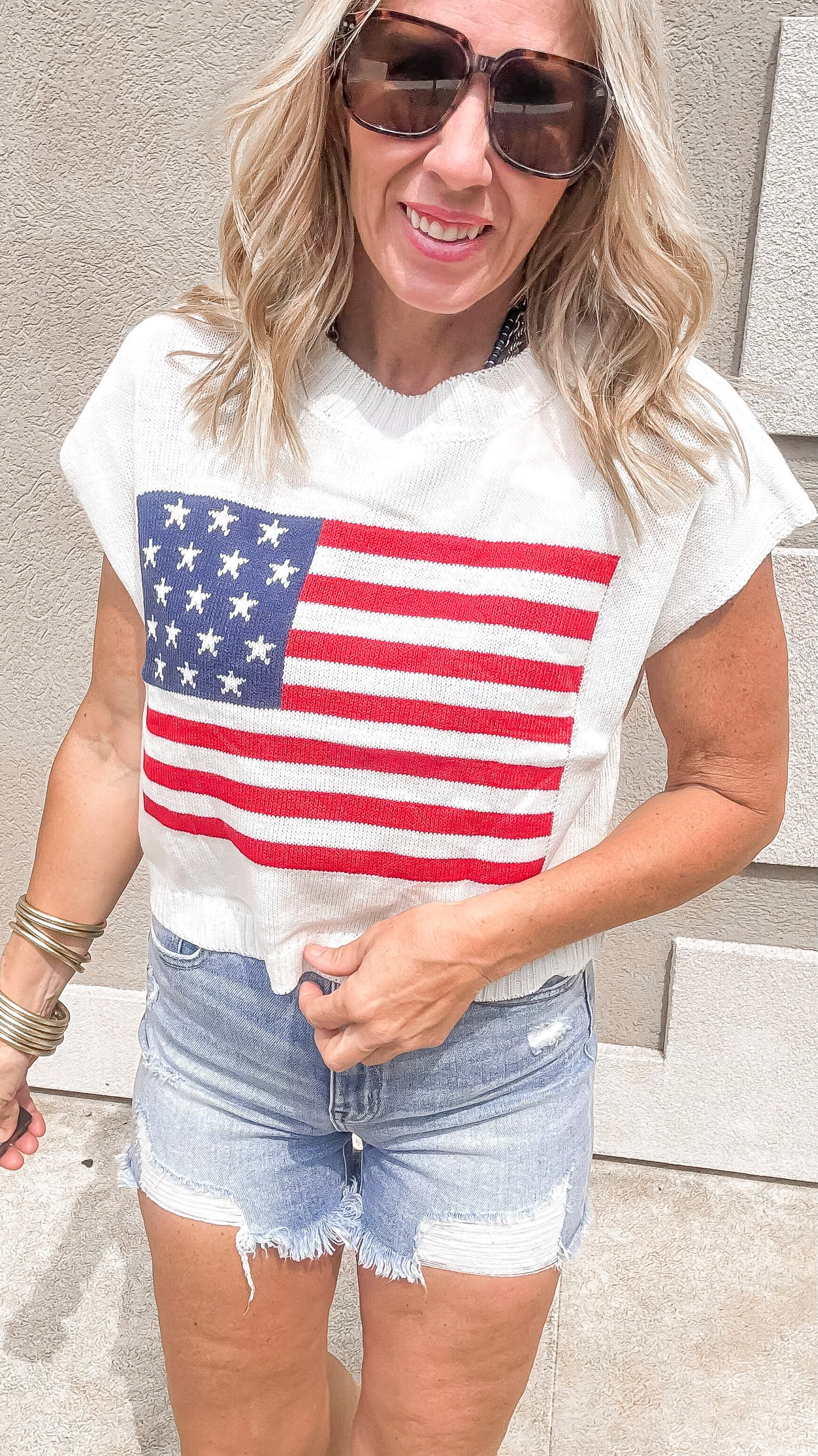 Casual patriotic knit top with bold flag graphic and raw hem.