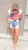 Stars and stripes flag sweater top paired with denim shorts.