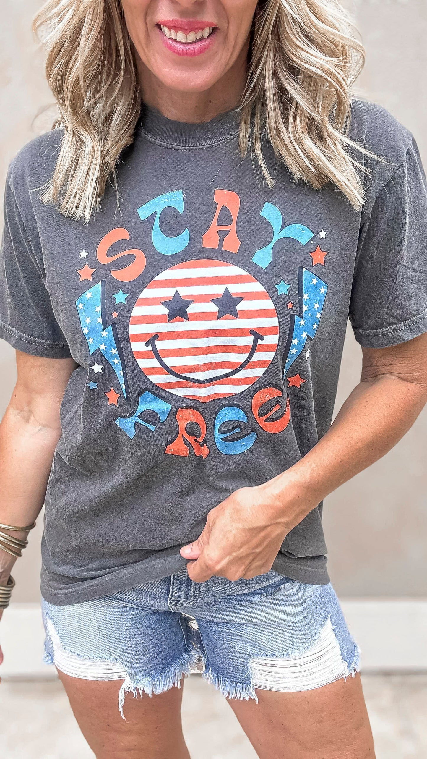 Patriotic smiley face graphic tee with red, white, and blue lettering.