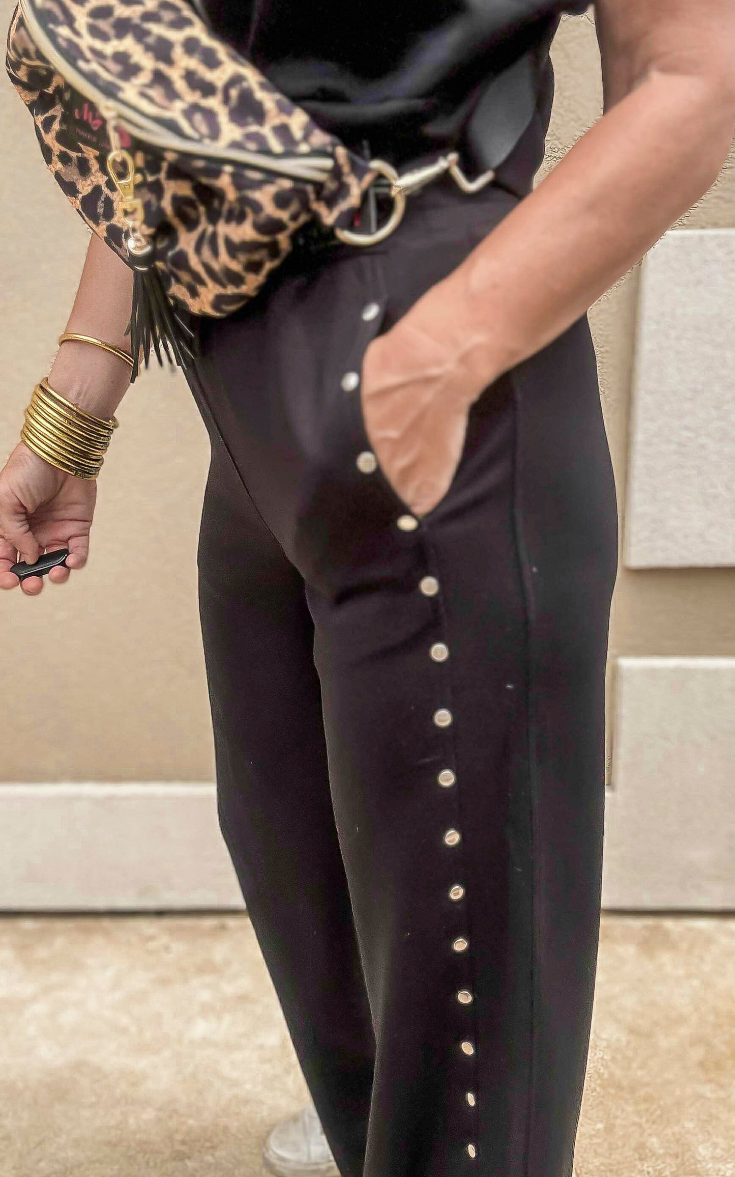 Elevated basics—black high-rise pants with statement studs and comfy stretch knit