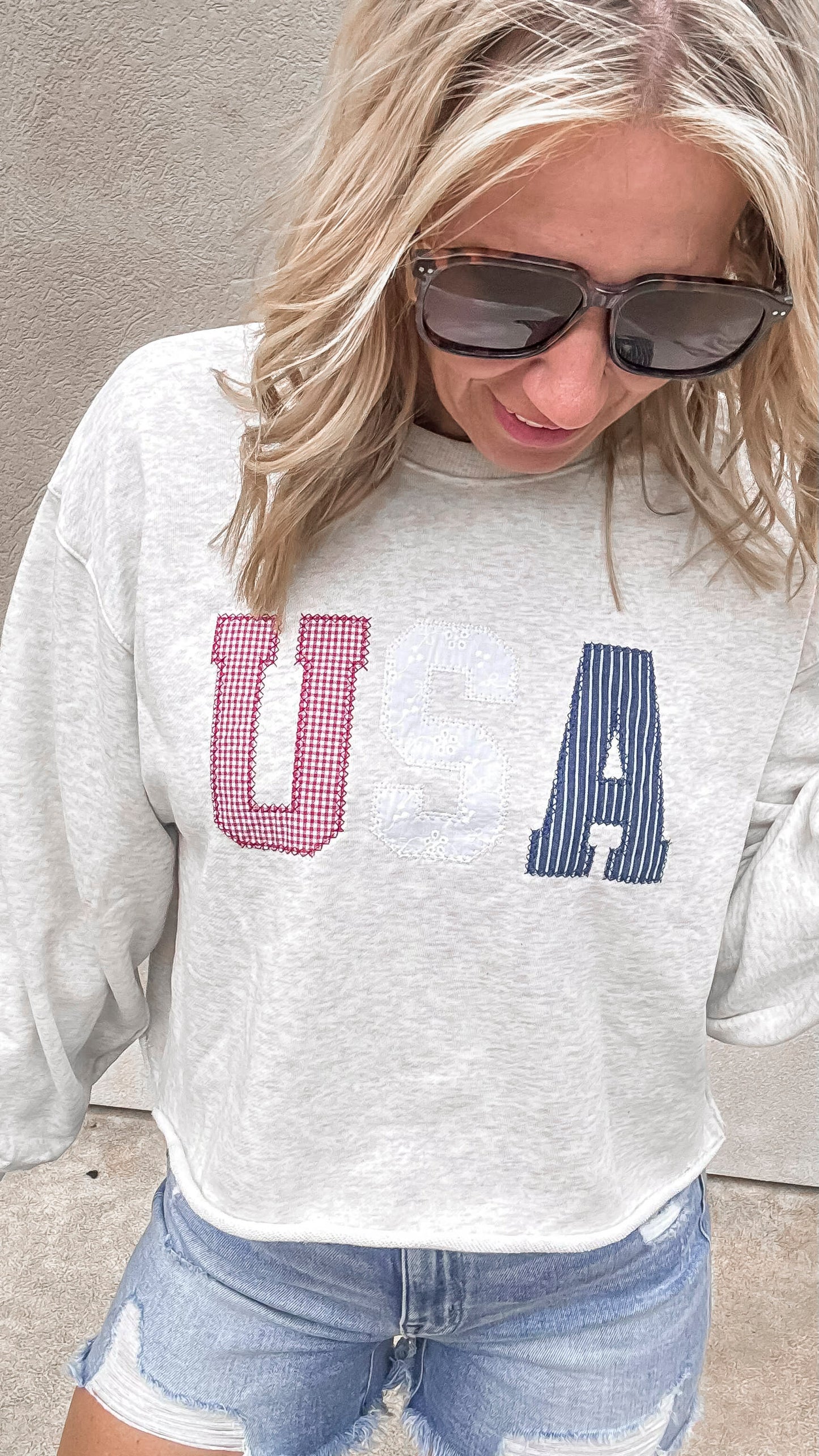 Patriotic USA sweatshirt paired with distressed denim shorts.