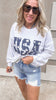 Patriotic USA embroidered pullover styled with distressed jean shorts.