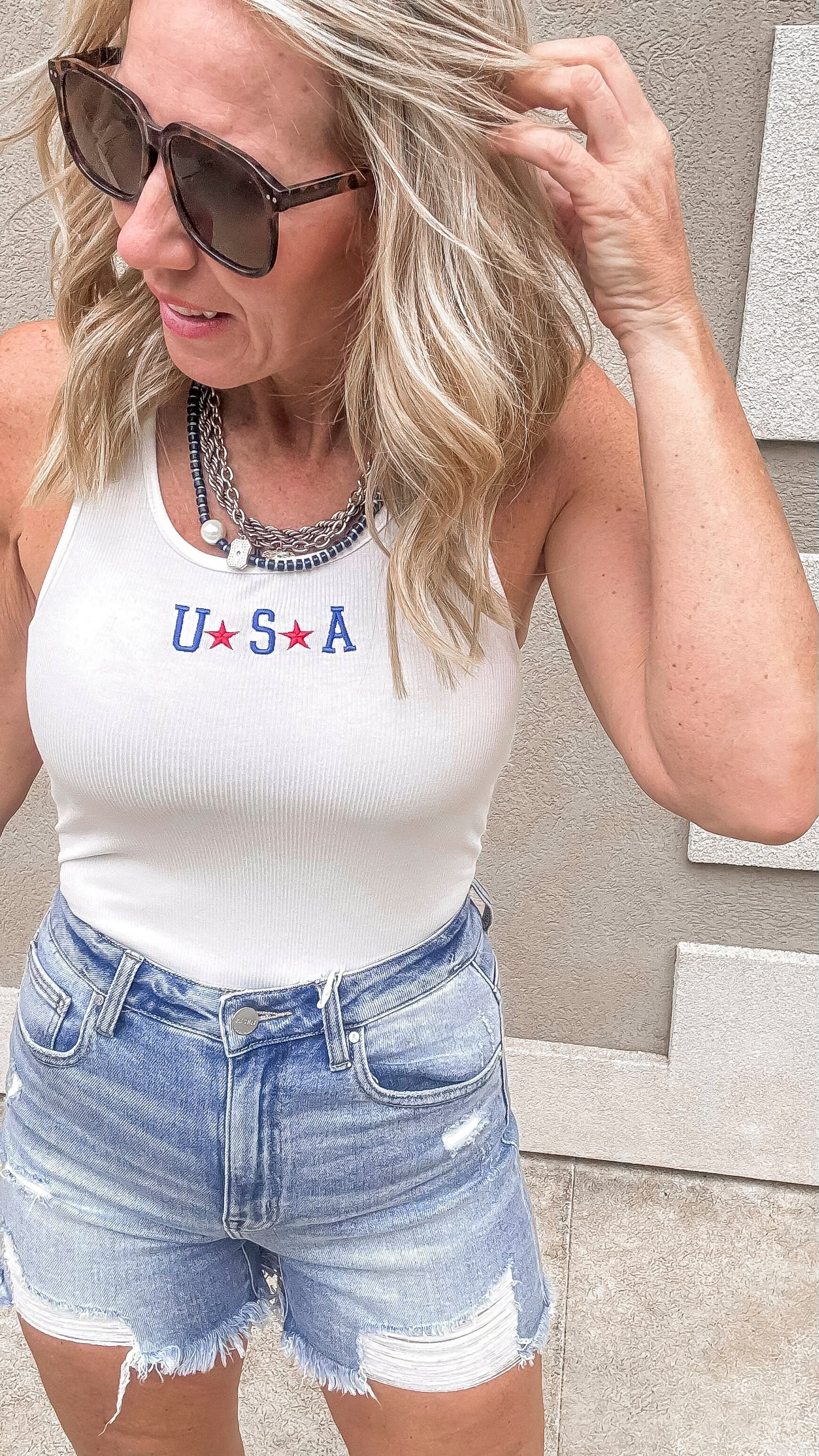 Patriotic bodysuit featuring Blue USA embroidery and cutoff shorts.