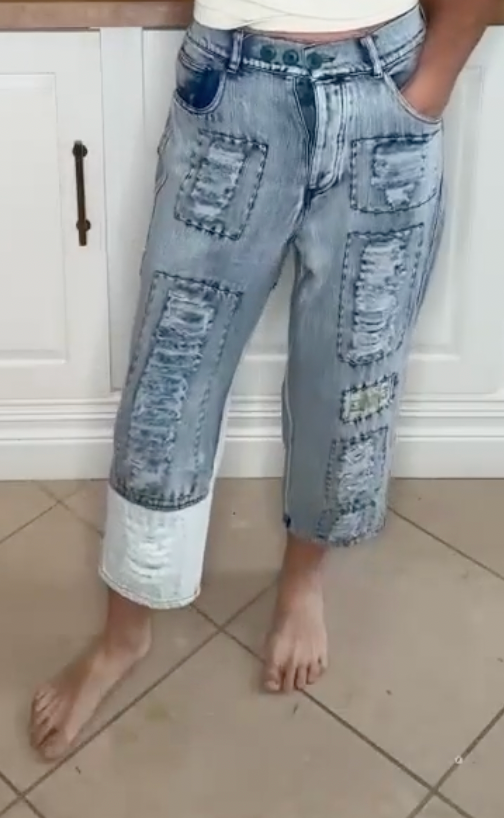 Distressed patchwork jeans with a cropped length and edgy street style.