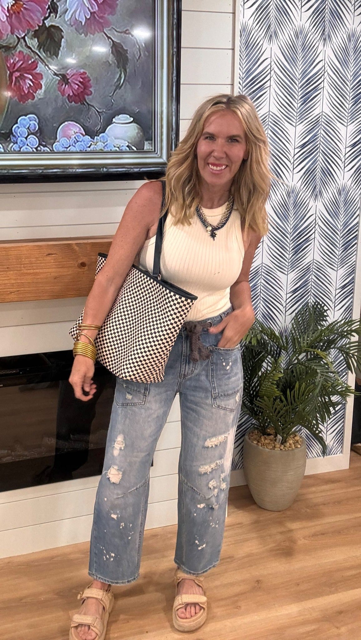 Casual washed jeans featuring ripped details and elastic waist paired with a ribbed white tank.