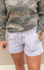 Close-up of soft grey fleece shorts featuring an elastic waistband, front pockets, and side hem detail.