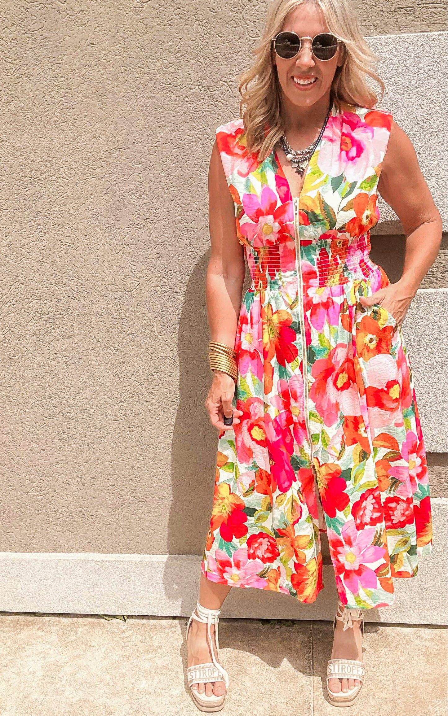 Bright floral zip-front sleeveless dress with gathered waist and flowy midi skirt.