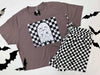 Gray t-shirt with ghost design and checkered shorts on a white background with black bats.