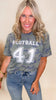 Woman wearing a camouflage t-shirt with 'FOOTBALL 41' text, standing against a plain background.