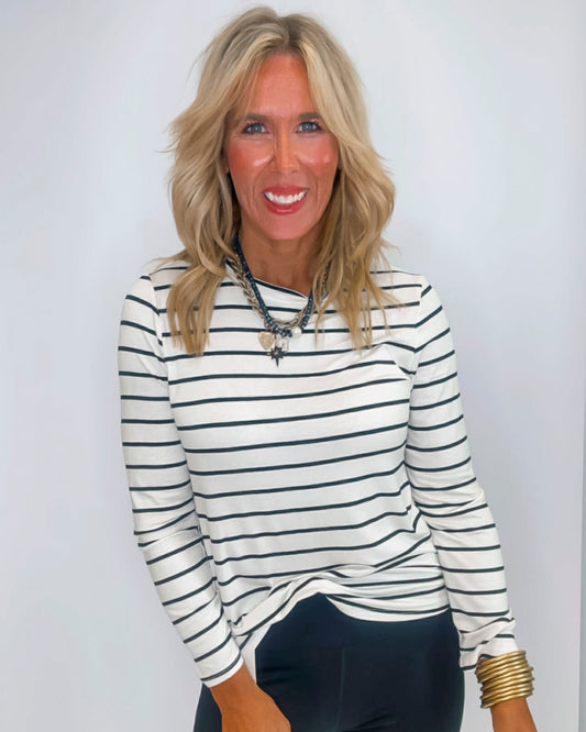 Woman wearing a striped long-sleeve top against a plain background