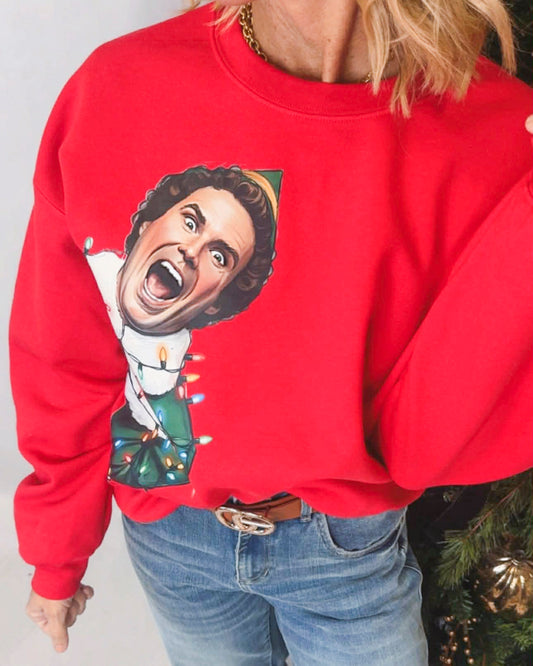 Red sweatshirt with a graphic design of a person in a festive outfit, worn by a person.