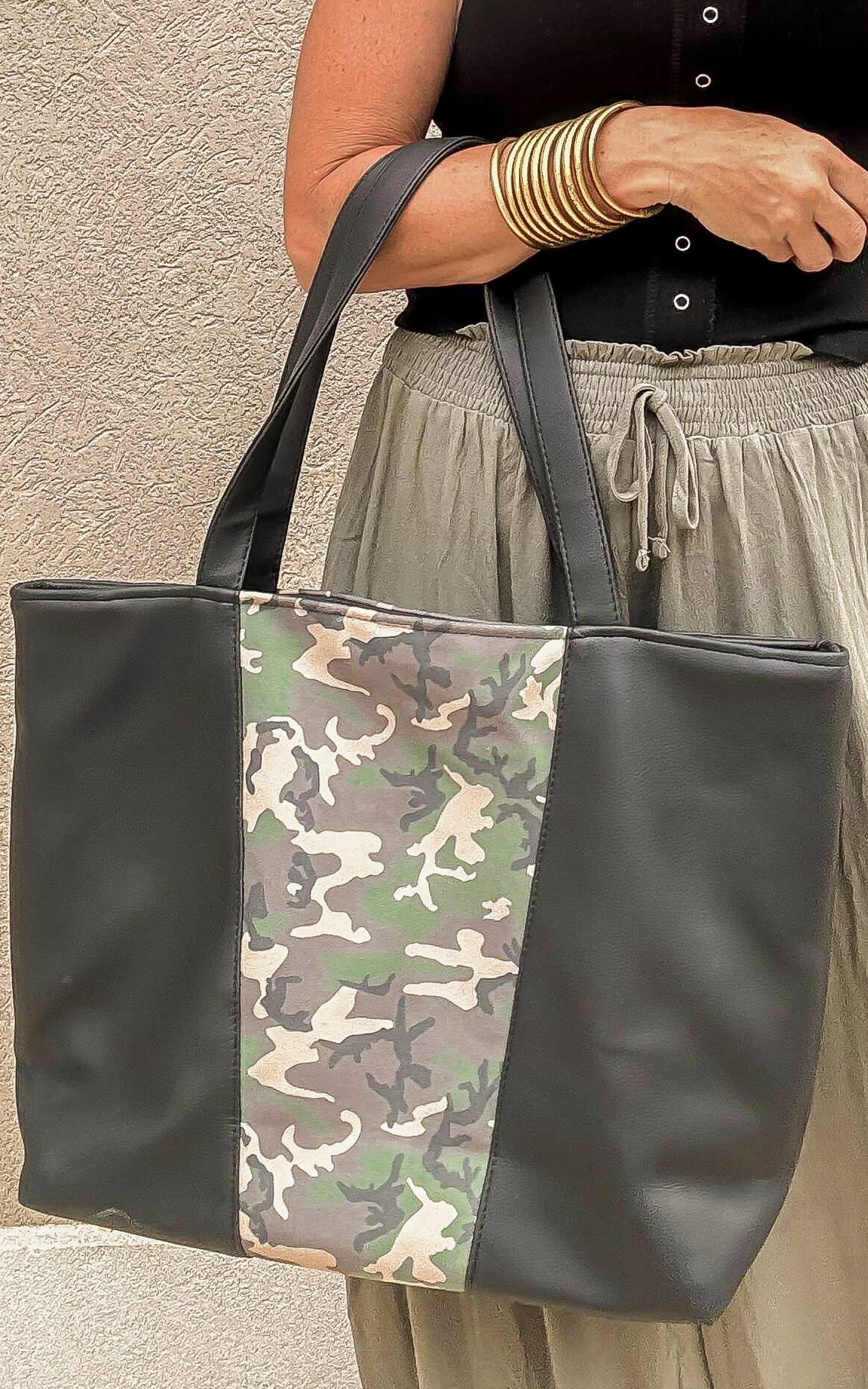 Camo and black weekender tote bag shown with neutral casual outfit, part of the Makeup Junkie & Bad Habit collab.