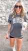 Faded black unisex t-shirt featuring bold camo 'River' lettering on chest.
