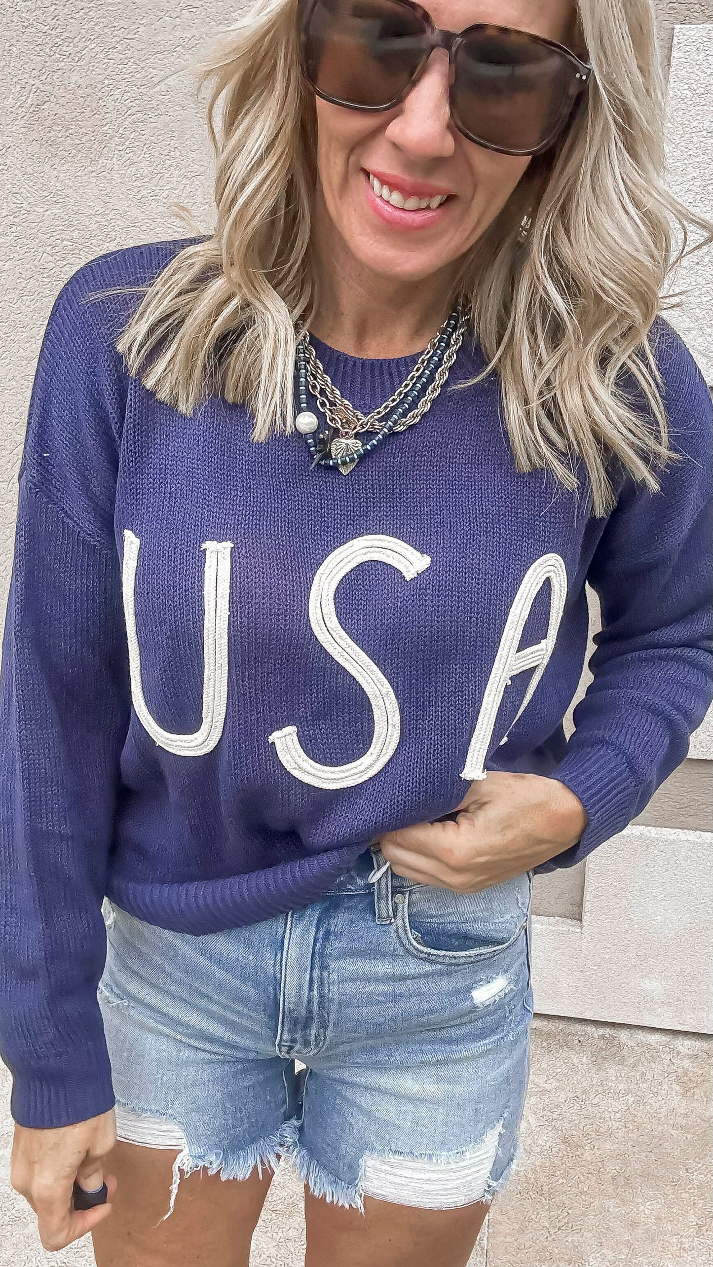 Navy vintage USA sweater paired with distressed denim shorts.
