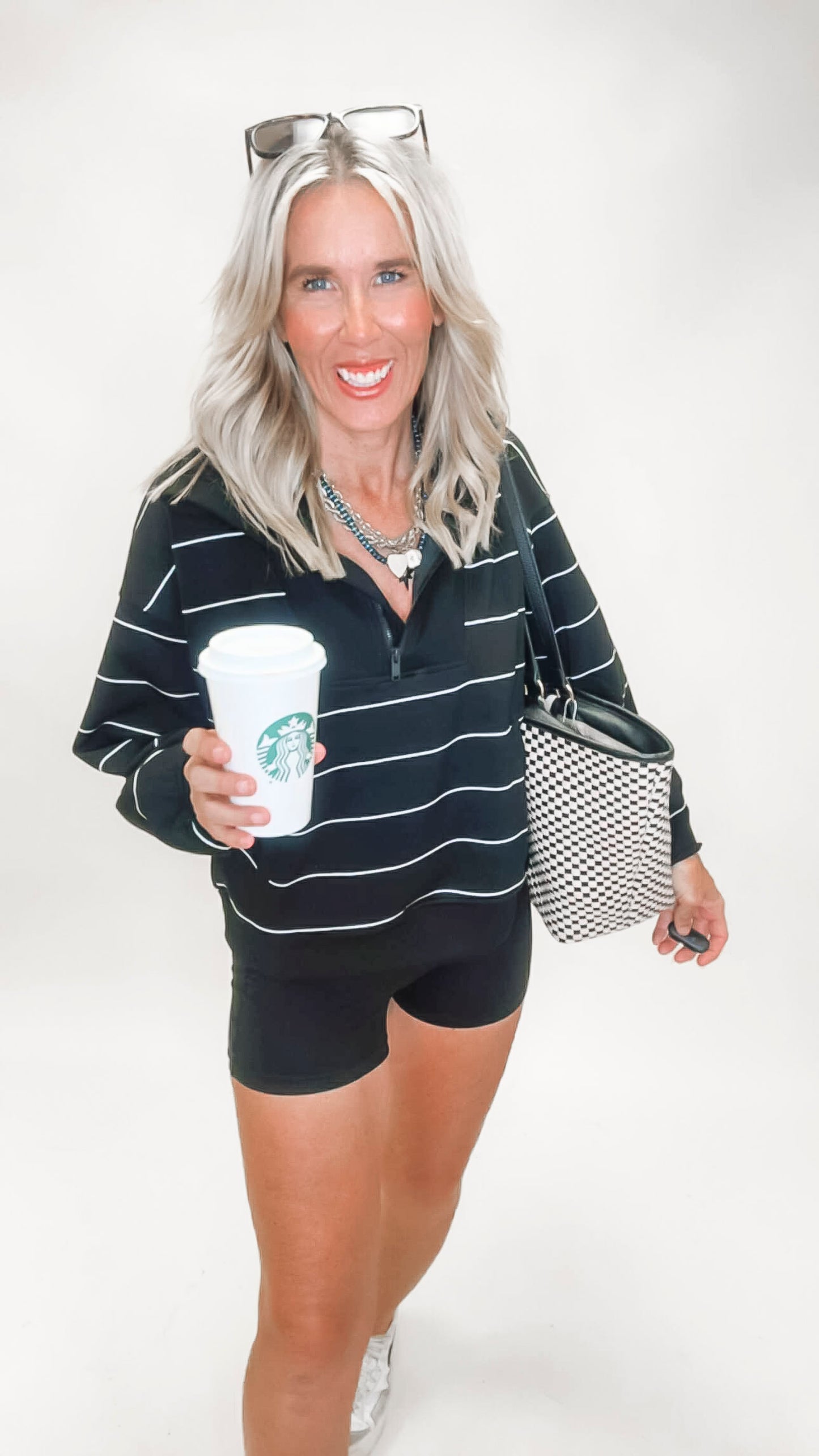 Women's black quarter zip pullover with white horizontal stripes and sleek mock neck design.