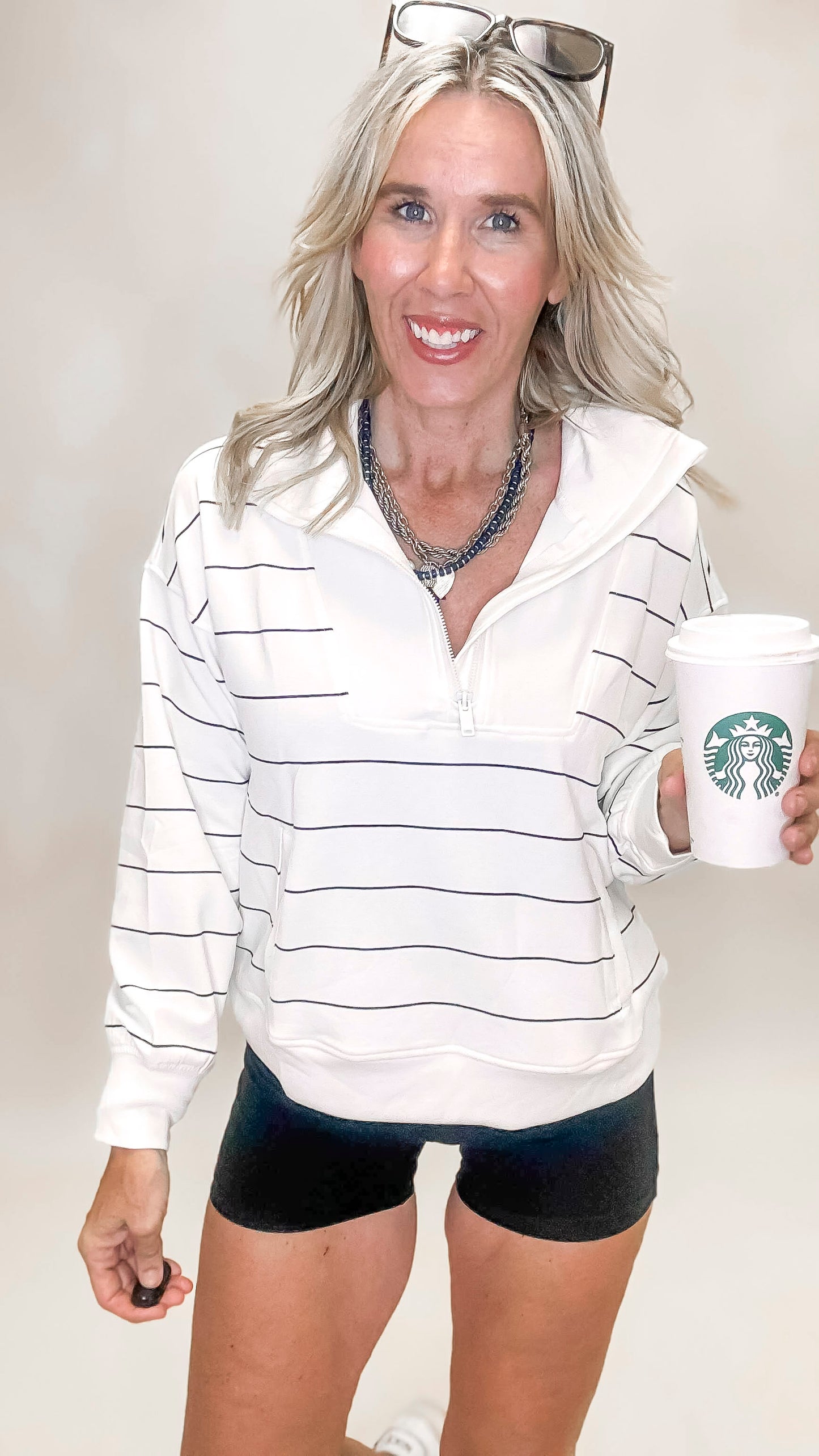 White and black striped mock neck pullover with zip-up detail and relaxed fit for casual-chic style.