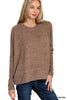 Woman wearing a brown sweater and blue jeans on a white background