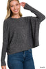 Woman wearing a gray sweater and blue jeans on a white background