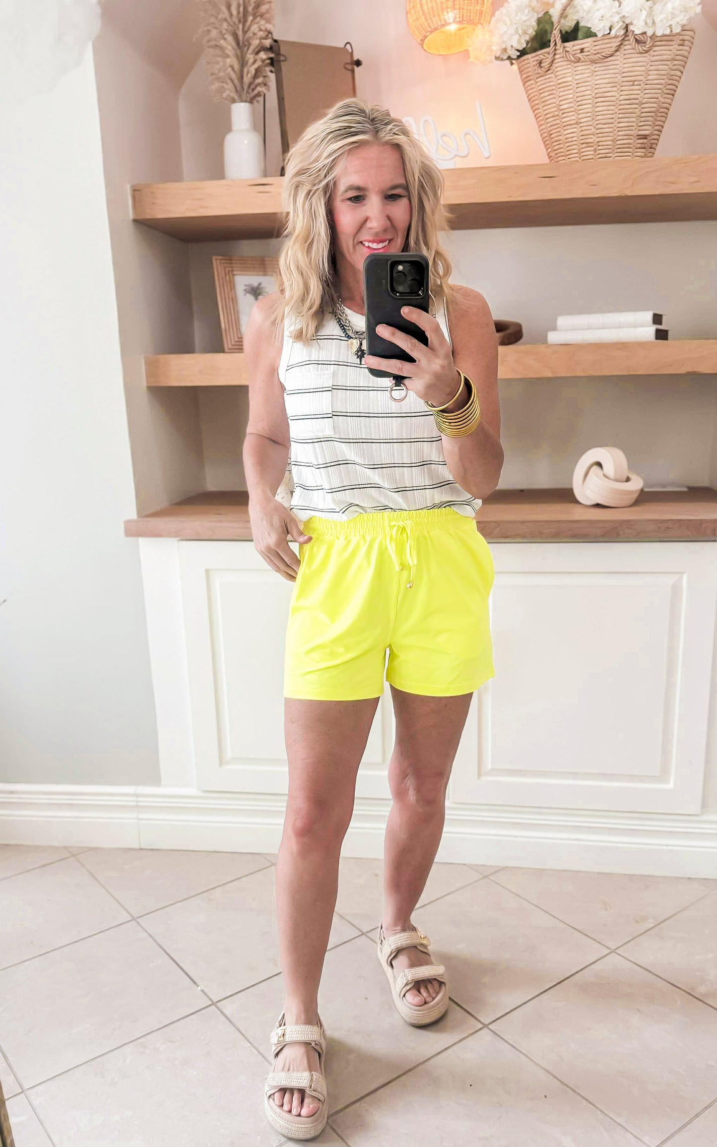 neon yellow shorts paired with stripe tank top 