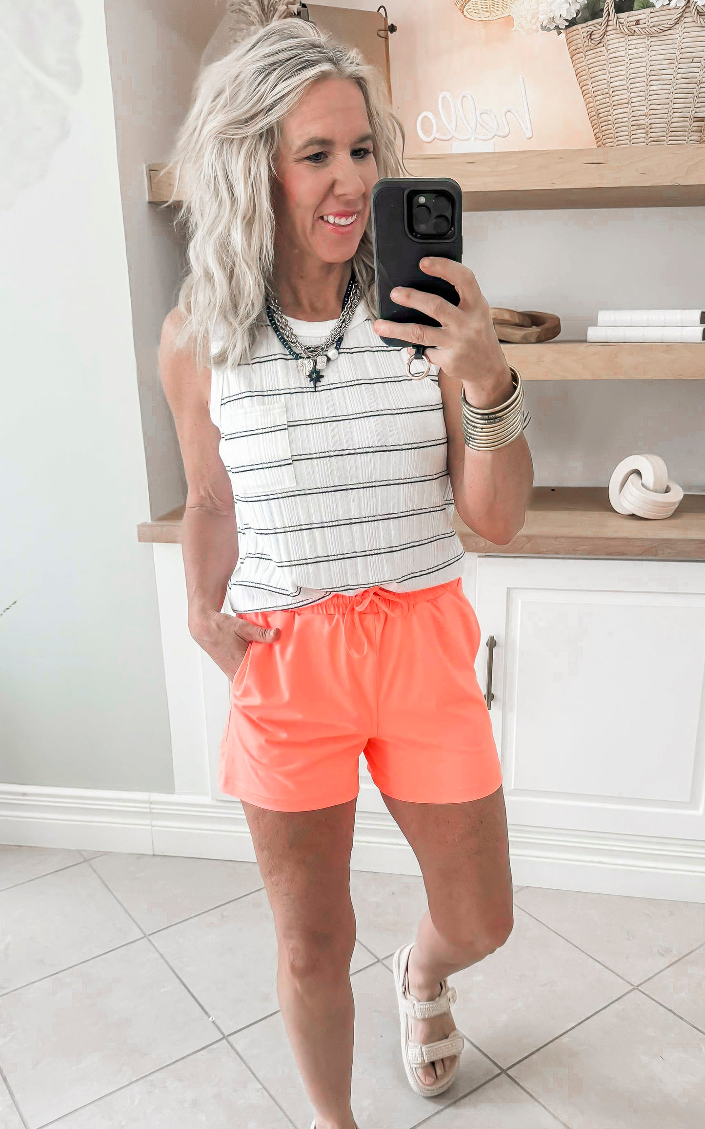 neon coral shorts paired with white/black stripe top