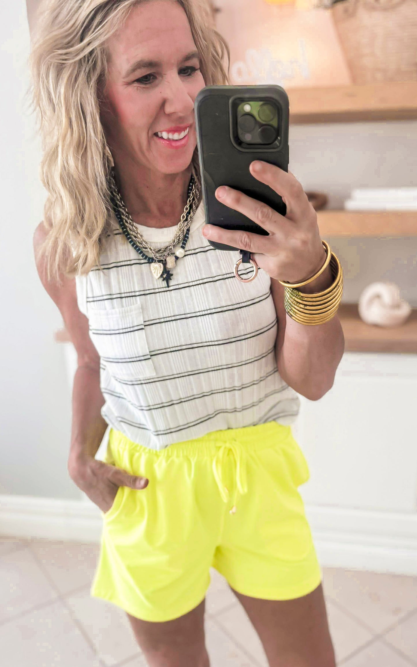 Woman wearing bright yellow lounge shorts with side pockets and elastic waist
