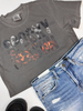 Vintage-inspired Halloween tee with bold spooky typography and layered ghost and pumpkin imagery.
