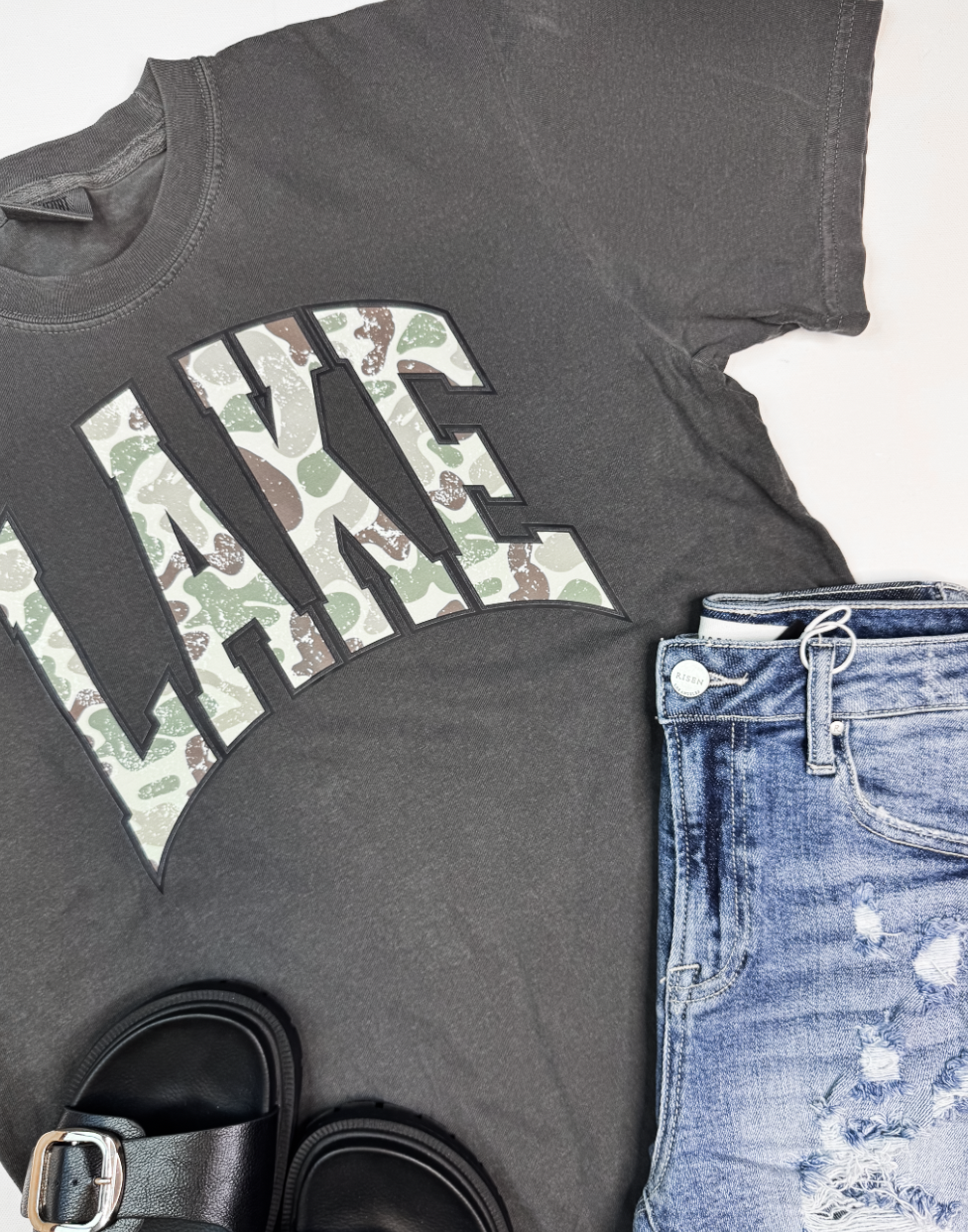 close up of graphic tee with the word Lake on it in Camo Print. 