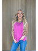 Woman wearing a pink sleeveless top and blue jeans with a striped background