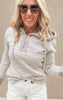 Close-up of a lightweight striped pullover hoodie in neutral tones, worn with high-rise white denim shorts.